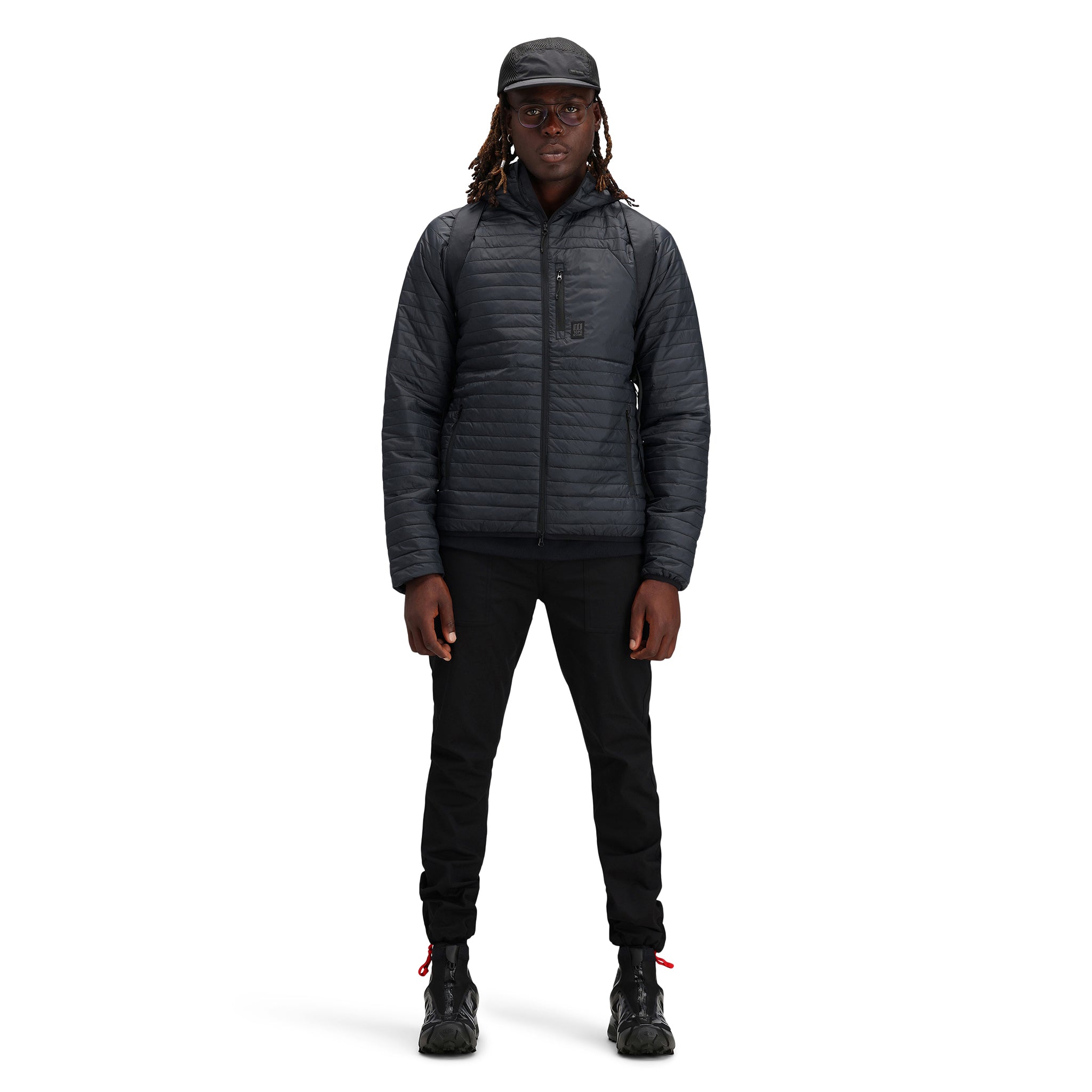 Modèle portant le Topo Designs Hommes Global Puffer packable recycled insulated Hoodie Veste en "black"