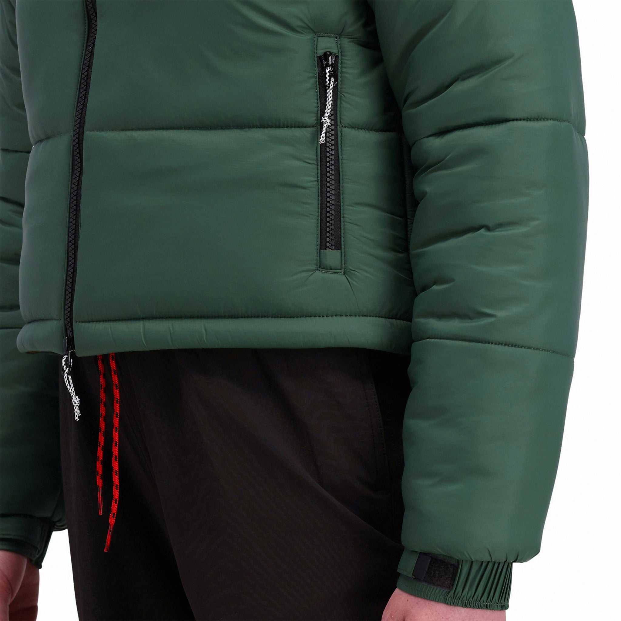 Modèle de face de la Veste isolée Topo Designs Femmes Puffer recycled en vert "Forest" montrant la pochette zippée pour les mains.