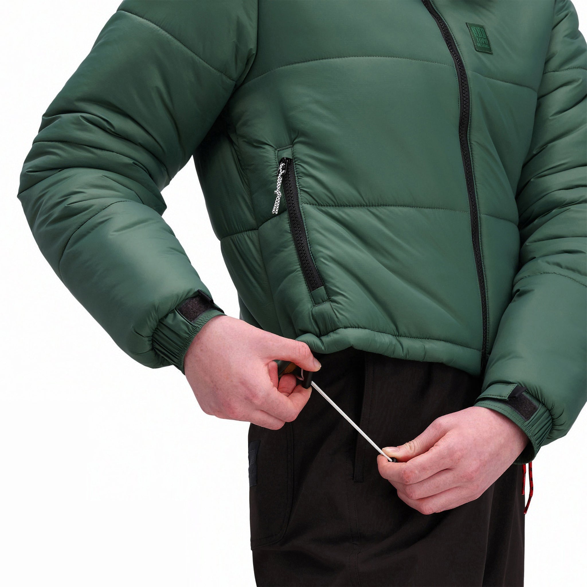 Vue générale du modèle de Topo Designs Femmes Puffer recycled insulated Veste en vert "Forest" montrant le cordon réglable à la taille.