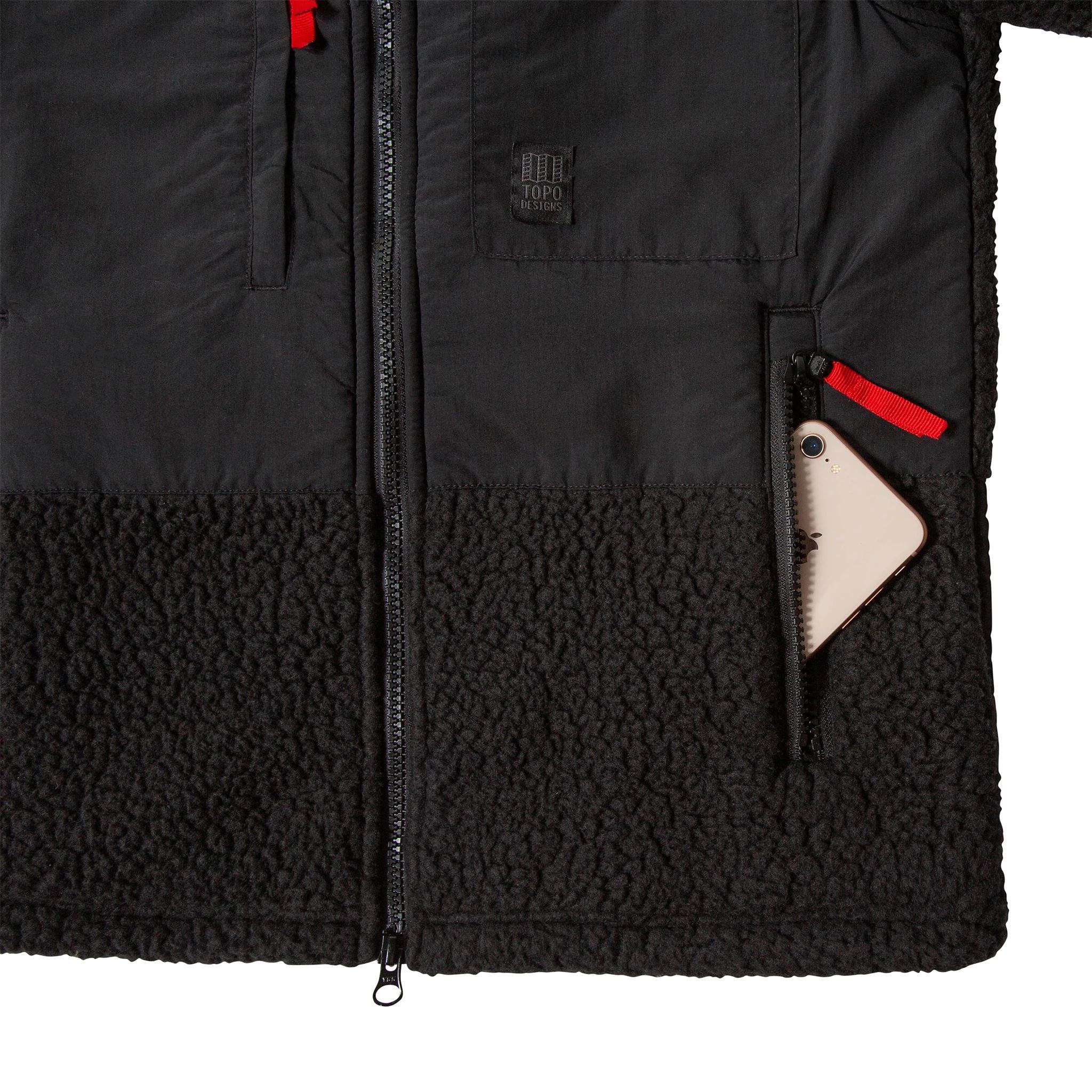 Vue d'ensemble du produit Hommes subalpine fleece en noir montrant la poche zippée ouverte.